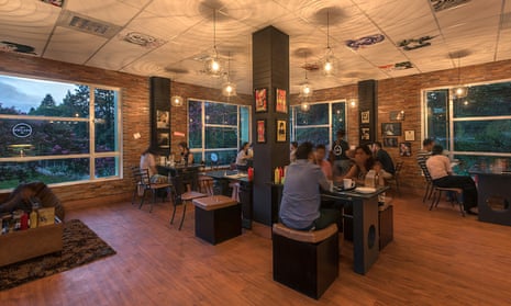 Customers sit at tables in Dylan’s Café in Shillong, India. The cafe is Bob Dylan-themed.