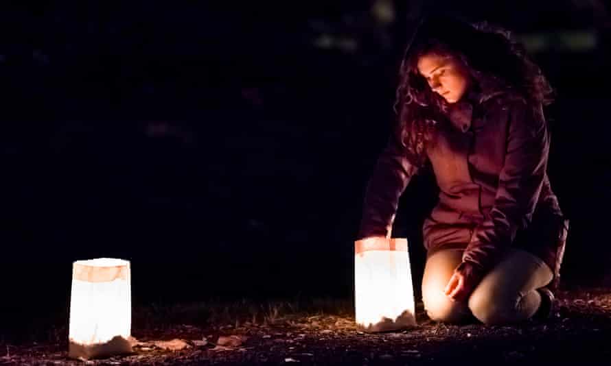 Young Woman lights lantern in paper bags at dark night,