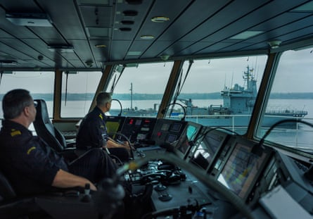 The coastguards sit in the bridge as a German naval ship passes in the sea outside the window