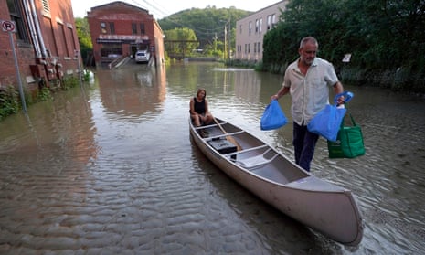 Jodi Kelly, seated center, practice manager at Stonecliff Veterinary Surgical Center, behind, and her husband Veterinarian Dan Kelly, right, use a canoe to remove surgical supplies from the flood damaged center, Tuesday, July 11, 2023, in Montpelier, Vt. The supplies included orthopedic implants for an upcoming surgery on a dog.
