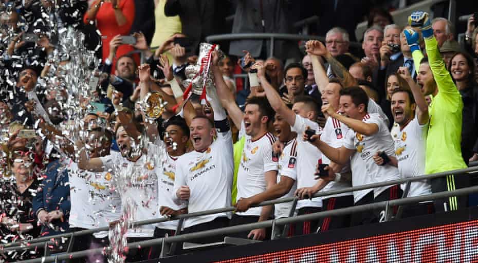 Manchester United’s Wayne Rooney and Michael Carrick lift the trophy as they celebrate winning the FA Cup.