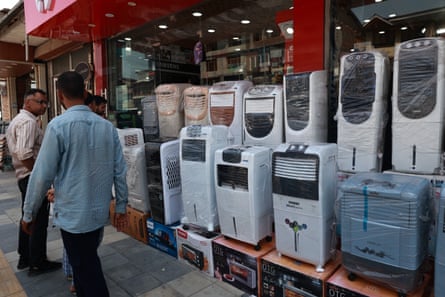 People look at air conditioners on sale outside of a store