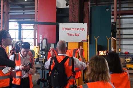Journalists look at a covered up sign during prime minister Scott Morrison’s visit to TEi engineering and steel fabrication company in Townsville.