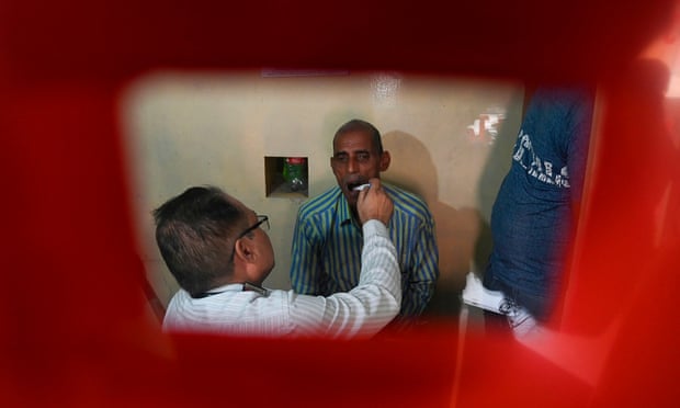 A doctor checks a suspected tuberculosis patient at a treatment centre in New Delhi