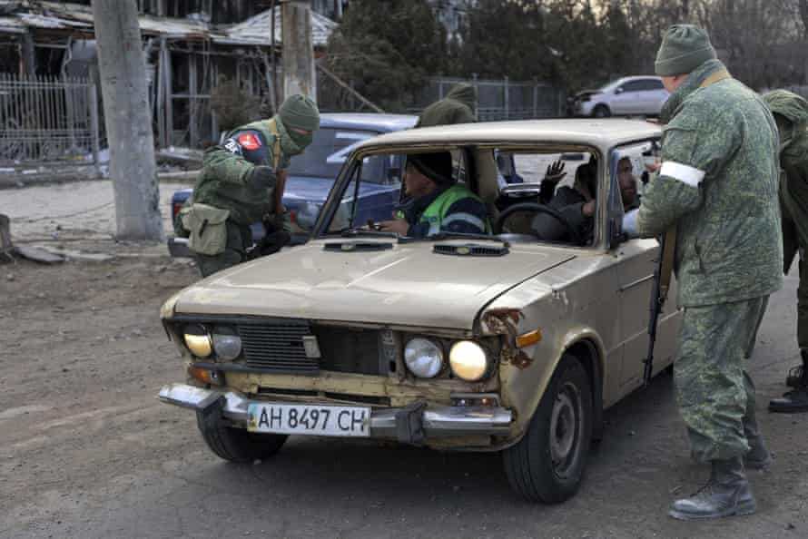 Servicemen of the self-proclaimed Donetsk People’s Republic inspect a vehicle at a checkpoint on the outskirts of Mariupol on Sunday.