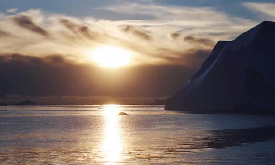 The sun sets beyond icebergs which calved from the Sermeq Kujalleq glacier float in the Ilulissat Icefjord in Ilulissat, Greenland