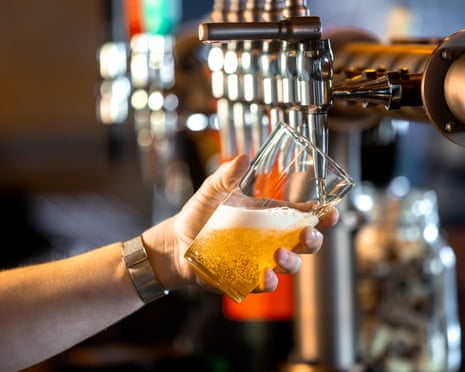 A man pouring a pint in a pub