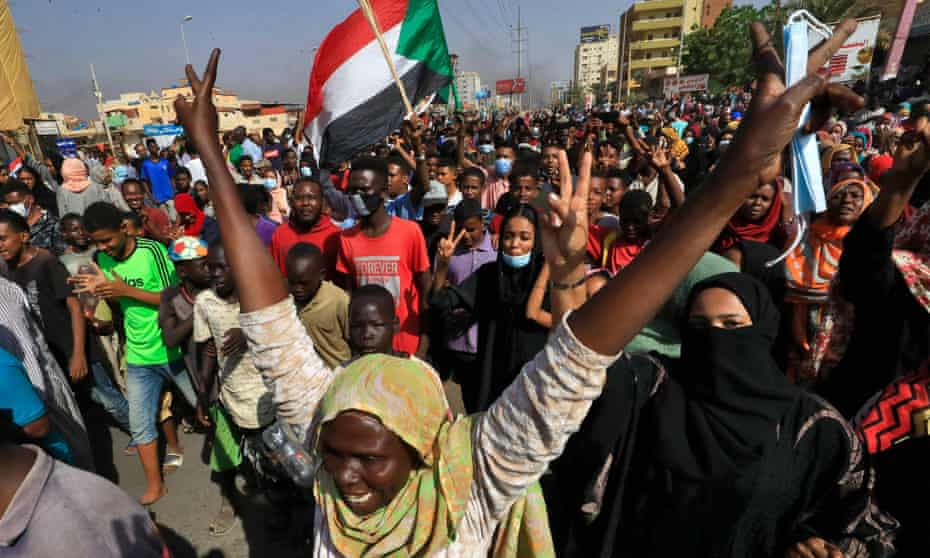 Protesters on the streets of Khartoum on Monday denounce the overnight detentions of government members.
