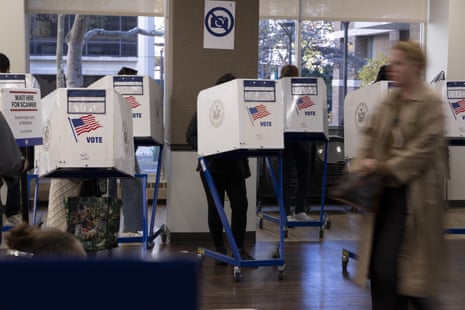 Voters use privacy booths printed with an American flag and "VOTE" at a New York City polling site
