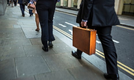 Man in suit carrying leather briefcase through City of London.