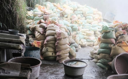 Piles of sand bags next to some buckets
