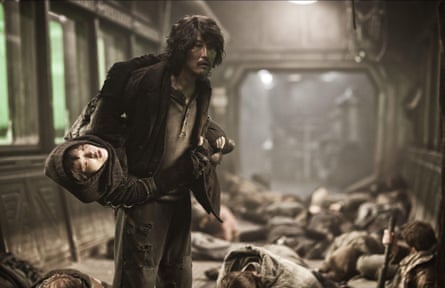 Kang-Ho Song carrying a child on a dingy train in Snowpiercer