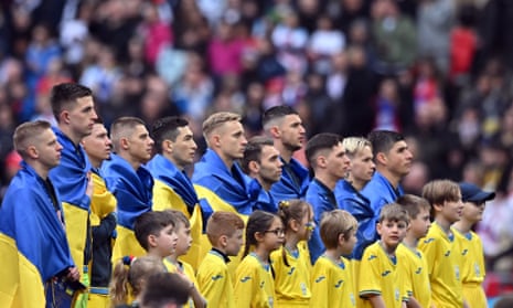 Ukraine players stand for their national anthem.