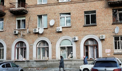 People walk past residential buildings damaged during a Russian drone and missile strike in Kyiv overnight.