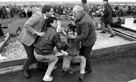 An injured man is aided by mourners