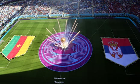 General view of a giant FIFA World Cup replica trophy and fireworks on the pitch alongside Cameroon and Serbia flags before the match.