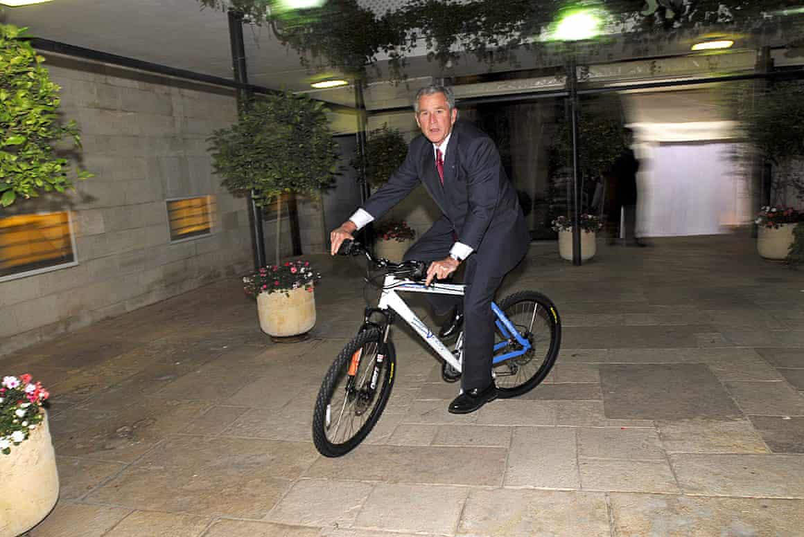 George W Bush riding a bicycle he received as a gift from the then Israeli prime minister Ehud Olmert