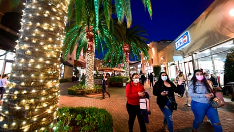 In this file photo taken on November 30, 2020 shoppers are seen at the Citadel Outlets in Los Angeles, California. California Governor Gavin Newsom announced on 3 December, 2020 new statewide bans on gatherings and “non-essential” activities, as hospitals in the nation’s most populous state face being overwhelmed by record Covid-19 cases.