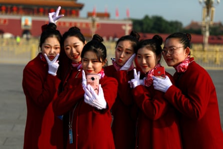 Hosts take selfies on Tiananmen Square before the closing ceremony of the 19th Communist party congress in Beijing