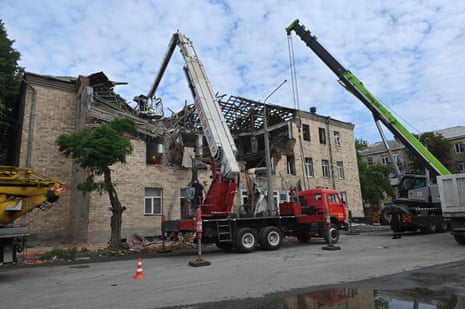 Rescuers clear debris after a drone hit an educational establishment, in Kharkiv.