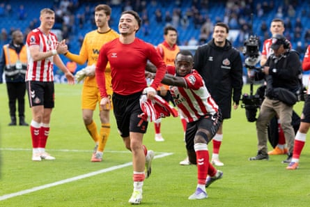 Noah Sadiki of Sunderland pushes teammate Chemsdine Talbi towards the travelling away fans at Chelsea