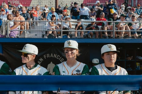Baseball players stand in a dugout