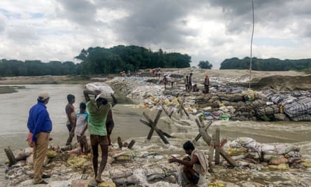 Locals gather building materials to build a dam as floodwaters flow from the north into Bihar near Muzaffarpur