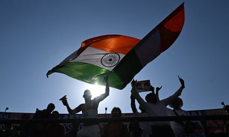 An Indian cricket fan waves the flag of India in the stands during