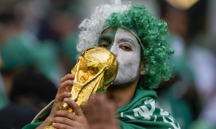 A Saudi Arabia supporter with a replica of the World Cup trophy during a match in the 2022 tournament.