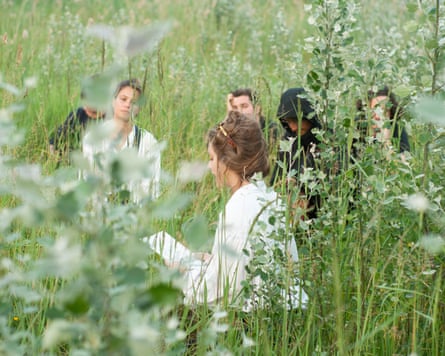 People perform among tall plants