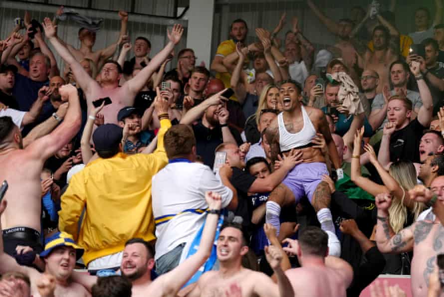 Leeds United’s Raphinha celebrates survival in the stands with the fans after their Premier League match at Brentford.