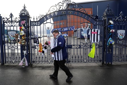 A fan leaves a tribute to Cyrille Regis at The Hawthorns.