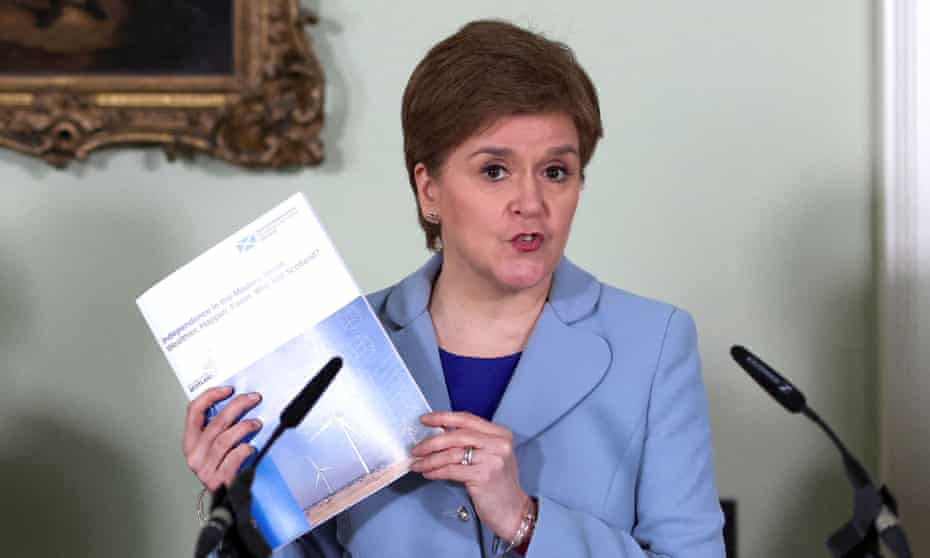Nicola Sturgeon holds up a copy of the pro-independence report at a news conference at Bute House in Edinburgh