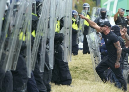 Crowds approach the line of riot police