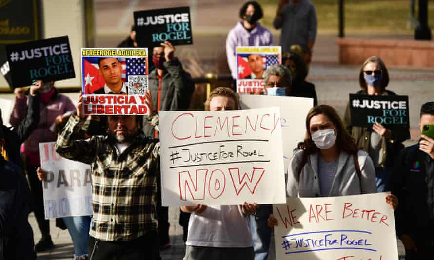 People hold signs in support of truck driver Rogel Aguilera-Mederos during a rally on the west steps of the state capitol