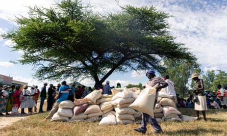 A man carries a full bag of donated maize grain in the Mutoko, Zimbabwe.