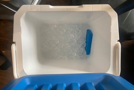 A blue and white cool box filled with ice cubes