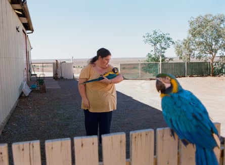 Hiedee Harris, 20, plays with her two blue-and-yellow macaws in front of her dugout on Turley’s Hill