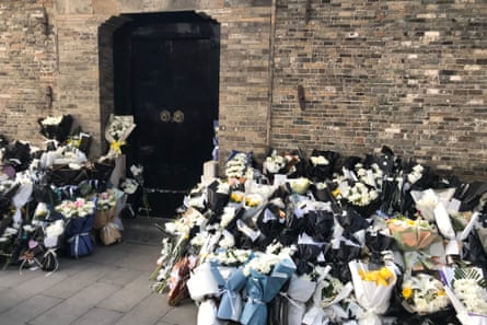 Ramos de flores colocados por los dolientes frente a la antigua casa de Ximen en la ciudad oriental de Yangzhou.