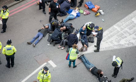 Police officers try to remove activists lying in the road