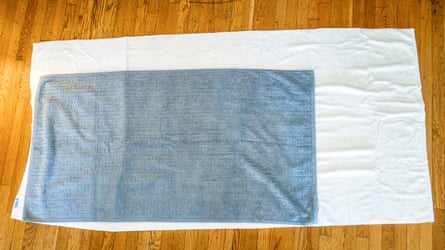 An American Soft Linen Oversized Bath Sheet with a regular bath towel on top of it