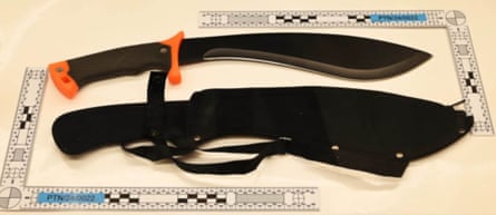 A large black metal knife and its holster, in a police photo