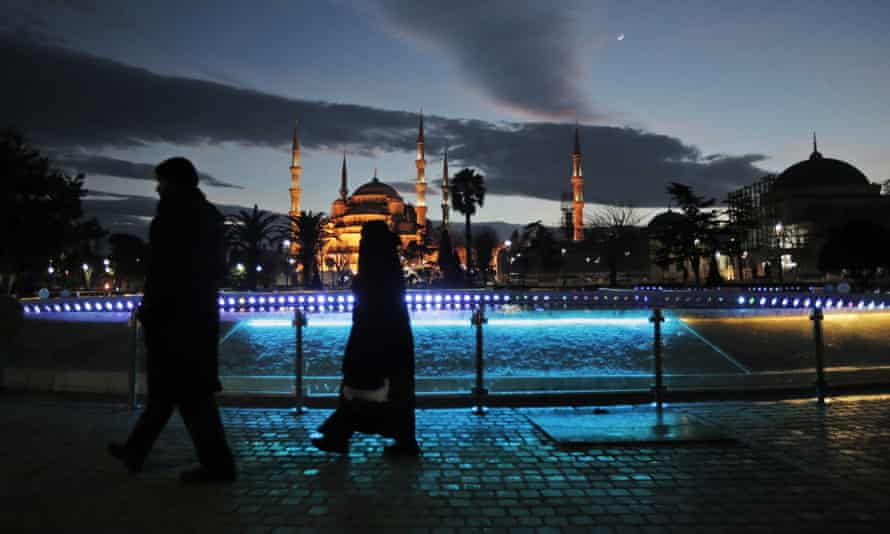 Tourists walk backdropped by the Sultan Ahmed Mosque, better known as the Blue Mosque, in the historic district.