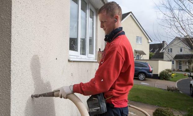 A man fills a cavity wall with insulation.