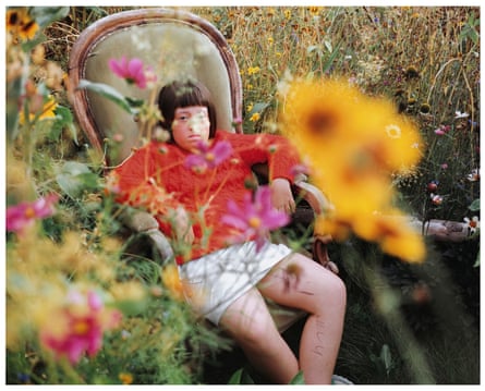 Siân Davey’s daughter Alice sitting in a straw chair in the garden