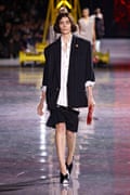 Model wears oversized blazer, shirt and skirts on the catwalk.