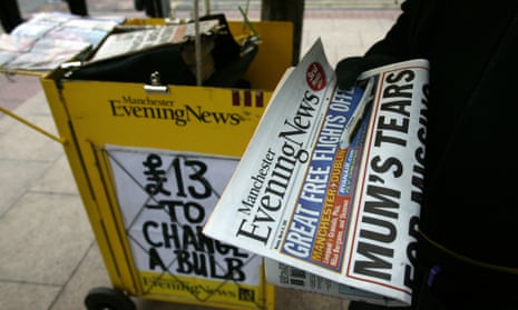 Street vendor sells Manchester Evening News.