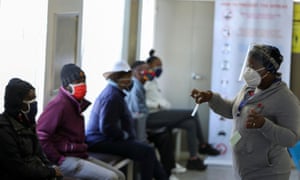 A medical worker talks to volunteers as they wait to receive an injection during the country’s first human clinical trial for a potential vaccine against the novel coronavirus, in Soweto, Johannesburg, South Africa.