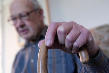 an older man using a walking stick to get about