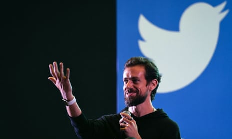 Former Twitter CEO turned competitor Jack Dorsey in front of the Twitter bird logo
